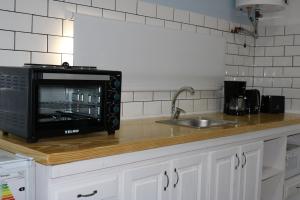 a kitchen counter with a microwave and a sink at OutBALoft in Capilla del Señor