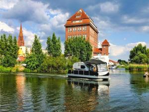VerchenにあるHouseboat on the Peene in Demminの建物前の川舟