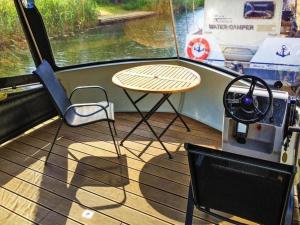 VerchenにあるHouseboat on the Peene in Demminのボートの上の小さなテーブルと椅子