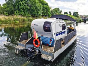 a small boat with a trailer on the water at Houseboat on the Peene in Demmin in Verchen +6 photos