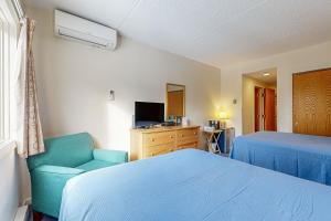 a bedroom with a bed and a chair and a television at 204 at Rivergreen in Lincoln +31 photos