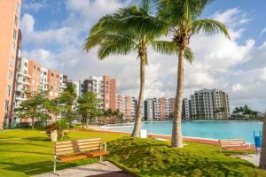 two palm trees in a park next to a body of water at Dreams Lagoon in Cancún