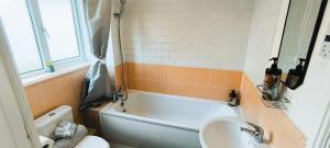 a bathroom with a tub and a sink and a toilet at 4 beds spacious Apartment, with Parking & WIFI, CHAFFORD HUNDRED, near station & shopping, long stays! in West Thurrock +27 photos