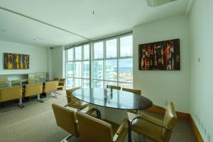 Un comedor con mesa y sillas y una gran ventana. en OZPED Flats Particulares Edifício Biarritz, en Brasilia 25 fotos más