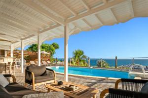 een patio met een zwembad en een tafel en stoelen bij Villa Alexandra in Saint-François