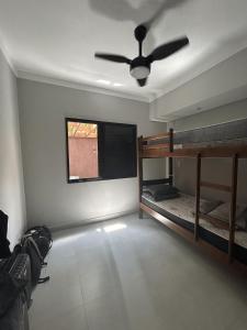 a room with two bunk beds and a ceiling fan at Condomínio Apoena in São Sebastião +8 photos