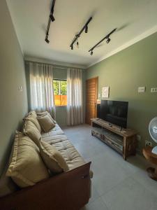 a bedroom with a large bed and a flat screen tv at Condomínio Apoena in São Sebastião