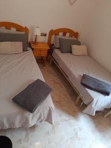 a room with two beds and a table with a lamp at Pinada Golf Apartment in Orihuela Costa +11 photos