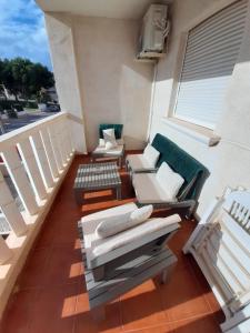a balcony with chairs and tables on a building at Pinada Golf Apartment in Orihuela Costa