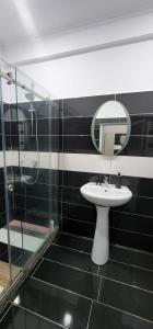 a bathroom with a sink and a glass shower at Hotel kleo Airport tirana in Tirana +20 photos