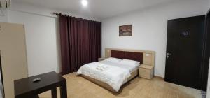 a small bedroom with a bed and a table at Hotel kleo Airport tirana in Tirana