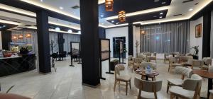 a restaurant with chairs and tables and a bar at Hotel kleo Airport tirana in Tirana