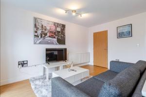 a living room with a couch and a tv at Modern 2 Bed Flat with Balcony, Easy London Access in London