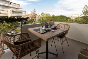 a table on a balcony with two chairs and a table at Liberty Suites II in Heraklio