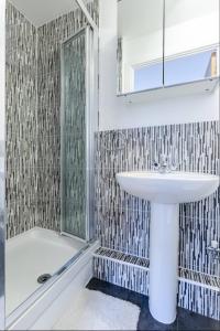 a bathroom with a sink and a shower at Modern 2 Bed Flat with Balcony, Easy London Access in London +24 photos