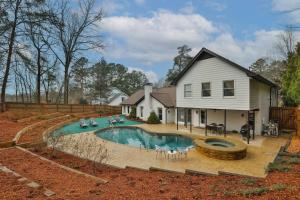 a house with a swimming pool in the yard at Sandy Springs Retreatpoolhottubking Bed in Atlanta