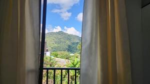 a window with a view of a mountain at Hostal SHELTER LA PERLA - San luis, Antioquia, Colombia in San Luis