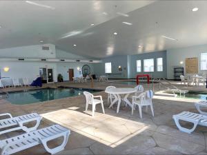 a pool with a table and chairs next to a swimming pool at Cobblestone Suites - Ripon in Ripon