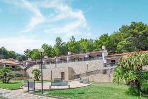 a building with a stone wall and benches at Villetta Luciana - Vieste in Pugnochiuso