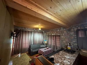 a living room with a couch and a stone wall at Ferme Tibrijine in Marrakech
