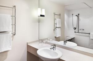 a white bathroom with a sink and a mirror at Crowne Plaza Sydney Macquarie Park by IHG in Sydney