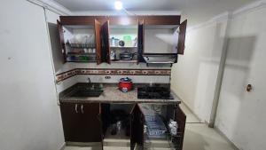 a small kitchen with a sink and a stove at Apartamento Acogedor - San Luis, Ant - Shelter La Perla Hostal in San Luis