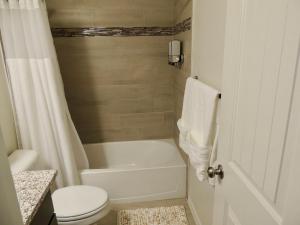 a white bathroom with a toilet and a tub and a sink at Comfortable new house in Homestead Meadows South +25 photos