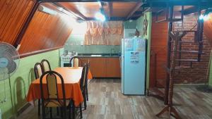 eine Küche mit Tisch und Kühlschrank in der Unterkunft Cabanas Junto al Rio in Panaholma