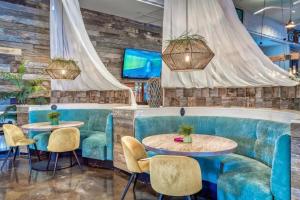 a restaurant with blue booths and tables and chairs at Sunrise Surprise 9th floor 2BR 2 BA King Suite Beach shuttle, heated pool! in Destin