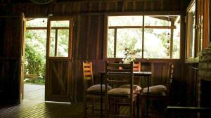 a room with two chairs and a table and two windows at Reserva Natural Don Rodolfo in Santa Ana