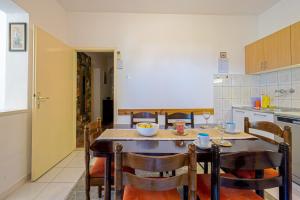 a kitchen with a table and chairs in a kitchen at Apartments Naki in Slatine
