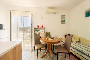 a small kitchen and dining room with a table and chairs at Apartments Naki in Slatine