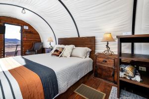 维尔京Zion White Bison Glamping & RV Resort的帐篷里有一张床的卧室