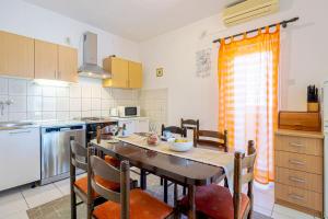 a kitchen with a table and chairs in a kitchen at Apartments Naki in Slatine