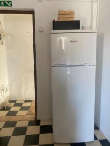 a white refrigerator in a room with a checkered floor at A Casa DAvo in Estremoz