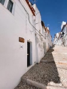 an alley with a white building with a door at A Casa DAvo in Estremoz