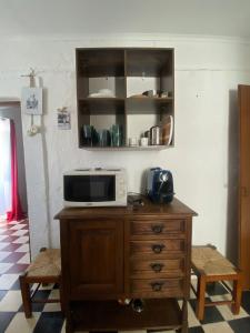 a microwave sitting on top of a wooden cabinet at A Casa DAvo in Estremoz