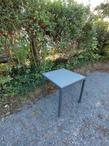 a bench sitting on the ground in front of some bushes at La room in Joue-les-Tours