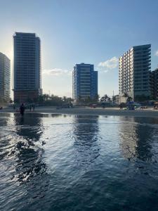 a body of water with buildings in the background at Apto aconchegante beira mar com ar no quarto in Solemar
