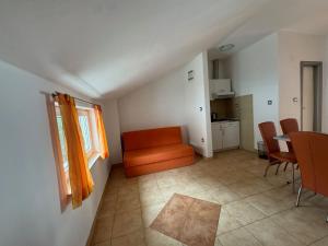 a living room with an orange chair and a table at Apartments Klara in Podaca