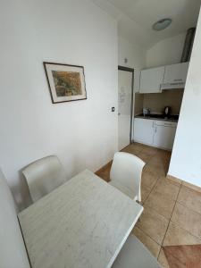 a kitchen with a table and two chairs and a table at Apartments Klara in Podaca