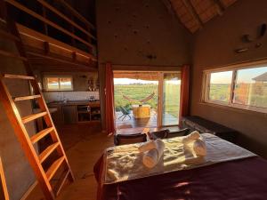 a bedroom with a bed and a view of a kitchen at Los Chajá Ecolodge in Barra de Valizas