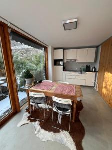 a kitchen with a wooden table and chairs and a kitchen with a window at Gästewohnung zum Atelier in Immenstadt im Allgäu