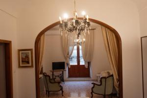 a large mirror in a living room with a chandelier at La Cortese, cuore barocco in Noto
