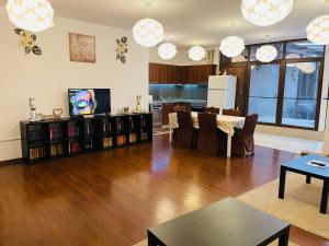 a living room with a hard wood floor and a kitchen at AUM House in Bucharest