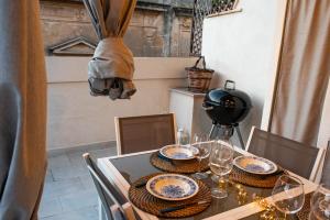 a dining room table with plates and glasses on it at La Cortese, cuore barocco in Noto