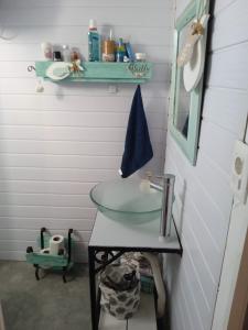 y baño con lavabo de cristal y estante. en San luis, en Ciudad de la Costa