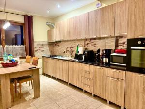 eine Küche mit Holzschränken, einem Tisch und einer Arbeitsplatte in der Unterkunft Dodi house in Timişoara