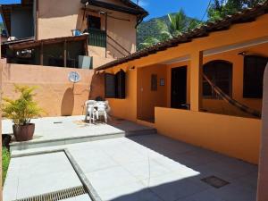 a patio of a house with two white chairs at Recanto do Saldanha in Angra dos Reis