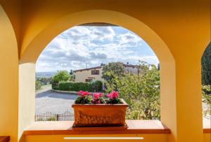 a window with a pot of flowers on a table at La Loggia del Ciliegio in Montespertoli